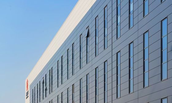 Entrepôt industriel à structure en acier avec porte enroulable et système de bardage en laine de roche ignifuge