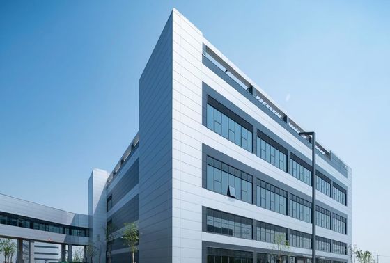 Entrepôt industriel à structure en acier avec porte enroulable et système de bardage en laine de roche ignifuge